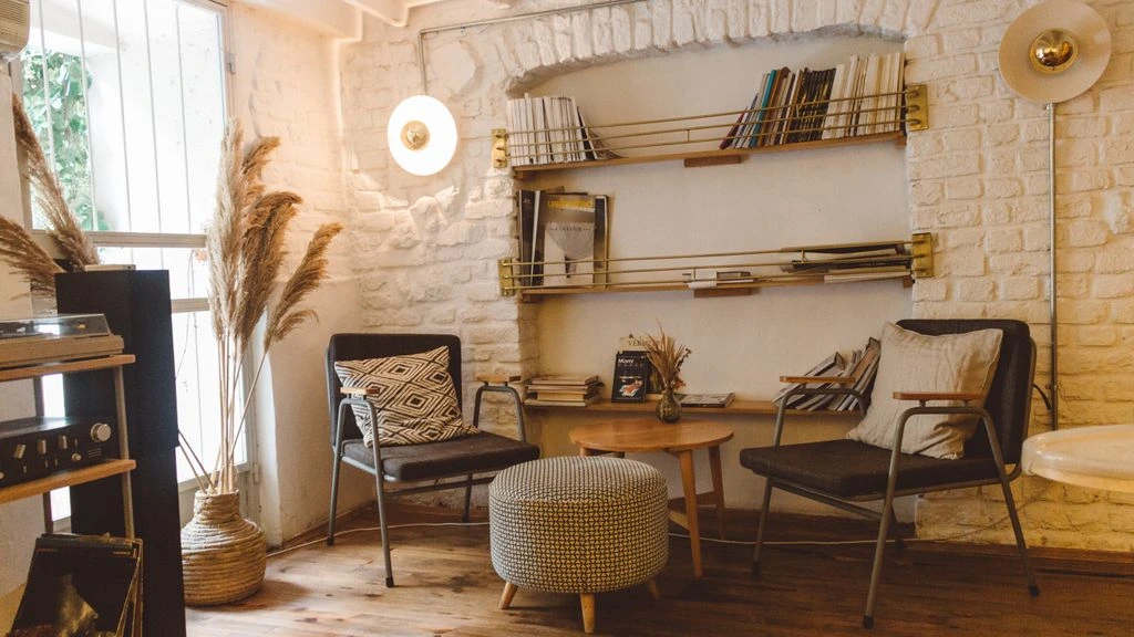 A warm, naturally lit living room styled with linen, terracotta, and olive green accents.