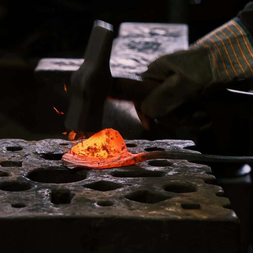 Hand-forged brass mirror against plaster wall