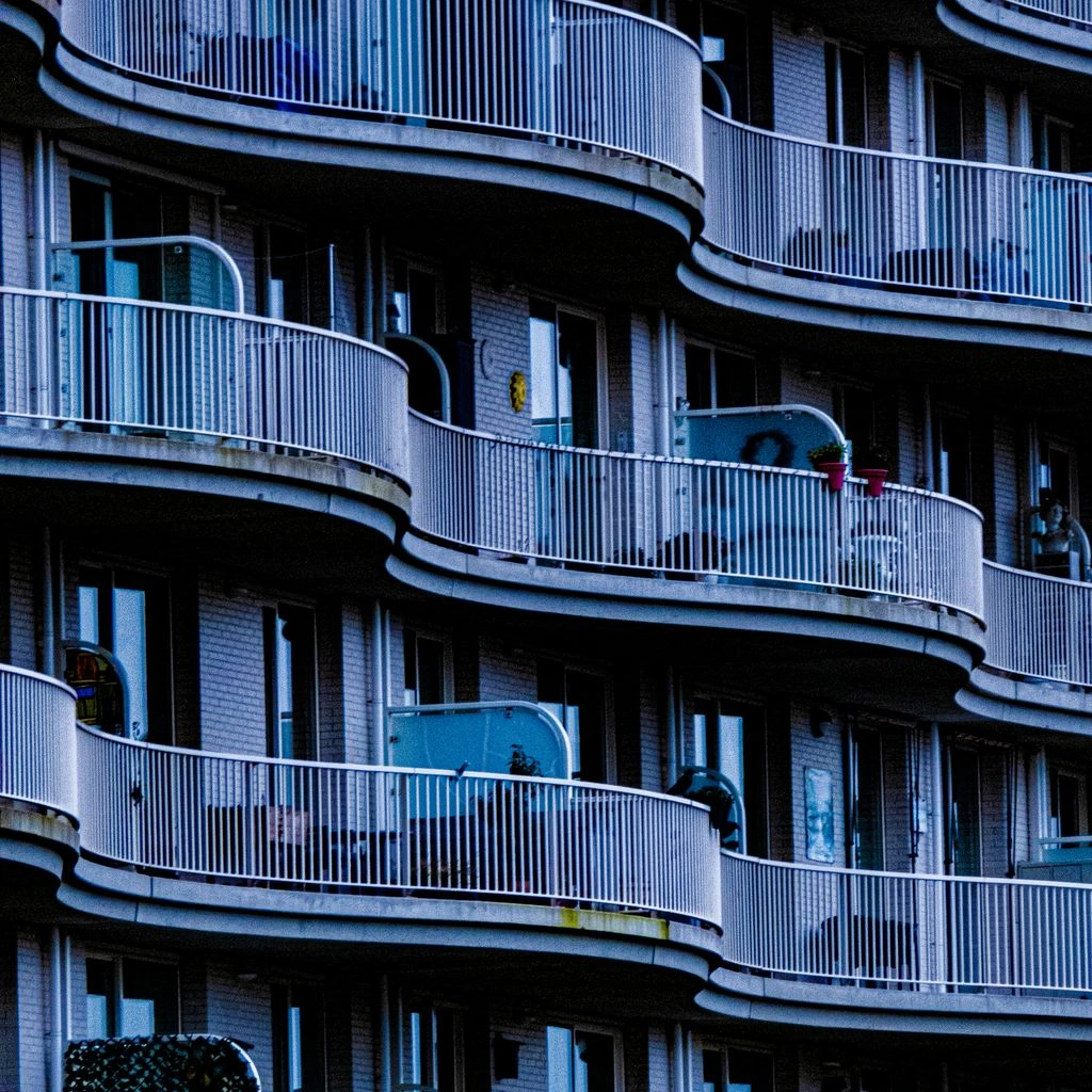 Urban balcony with terracotta planters and teak chair